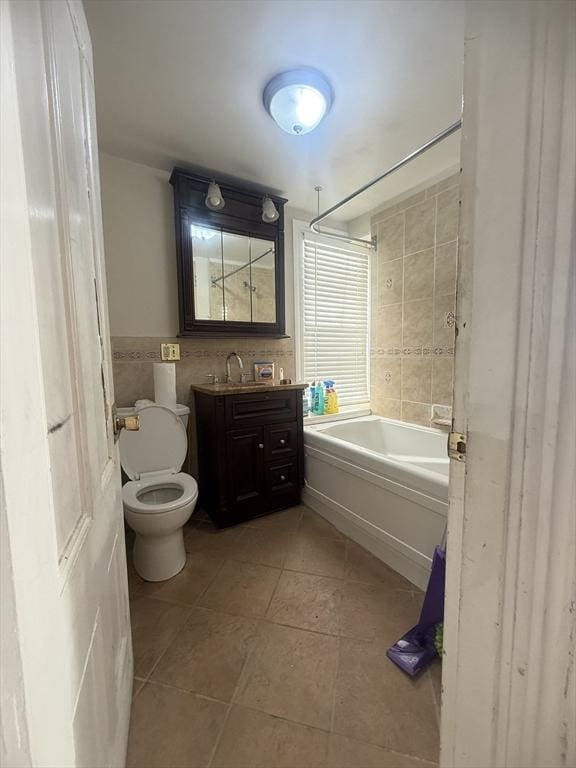 full bathroom with tile patterned floors, toilet, tile walls, vanity, and tiled shower / bath combo