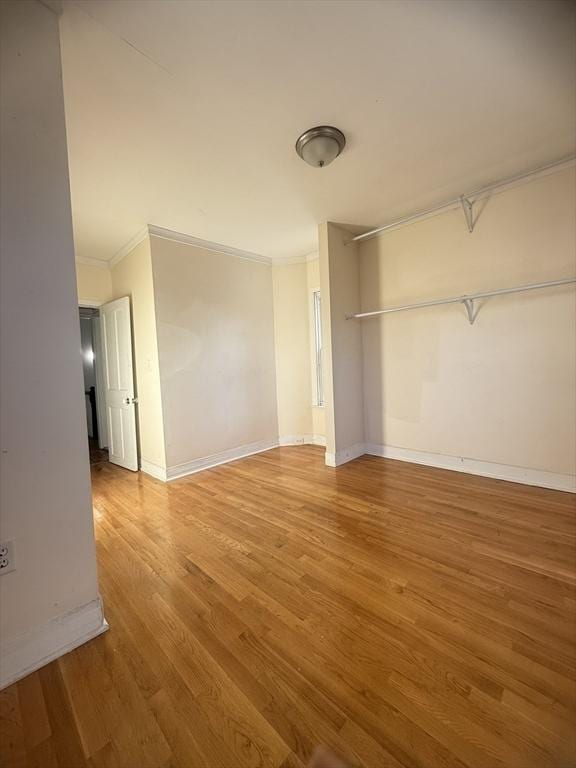 unfurnished bedroom featuring crown molding and hardwood / wood-style floors