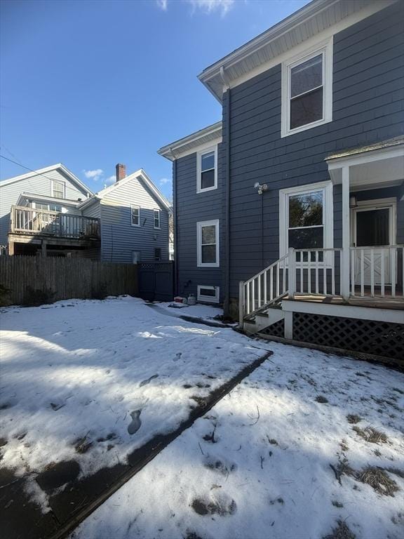 view of snow covered rear of property