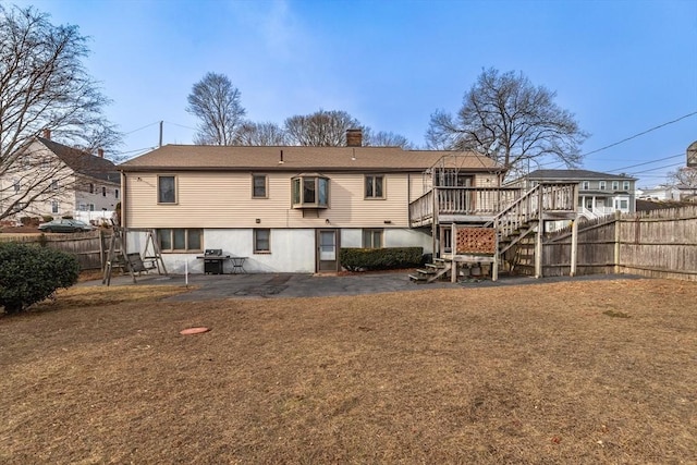 rear view of property with a yard and a deck