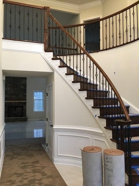 staircase featuring a fireplace and ornamental molding