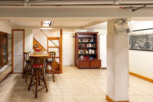 dining space featuring light tile patterned floors and baseboards