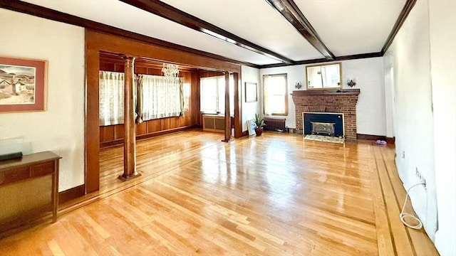 living room featuring light wood-style flooring, baseboards, ornamental molding, beam ceiling, and radiator