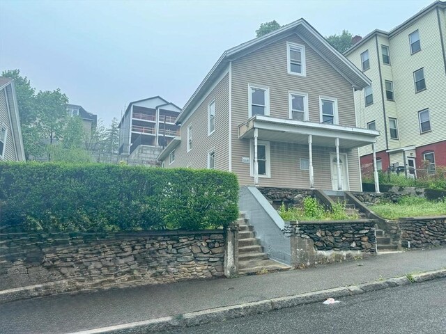 view of front of home with stairway and covered porch