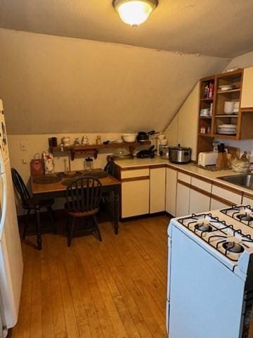 kitchen featuring white cabinetry, gas range gas stove, sink, and light wood-type flooring