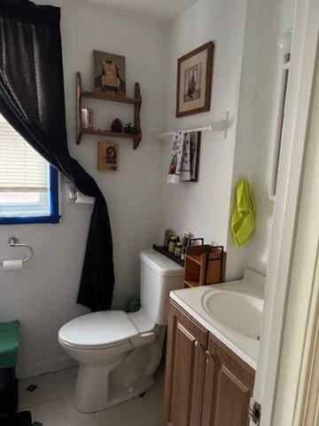 bathroom featuring tile patterned flooring, vanity, and toilet