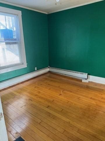 unfurnished room featuring crown molding, ceiling fan, a baseboard radiator, and light wood-type flooring