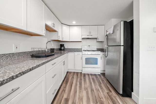 101 Old Westport Rd, Dartmouth, MA 02747 - kitchen featuring freestanding refrigerator, white range with gas stovetop, under cabinet range hood, white cabinets, and recessed lighting