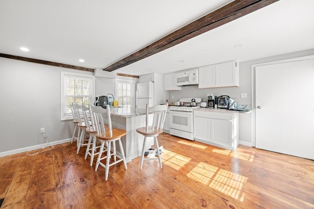 101 Old Westport Rd, Dartmouth, MA 02747 - kitchen with white appliances, a breakfast bar, white cabinets, beamed ceiling, and light wood finished floors