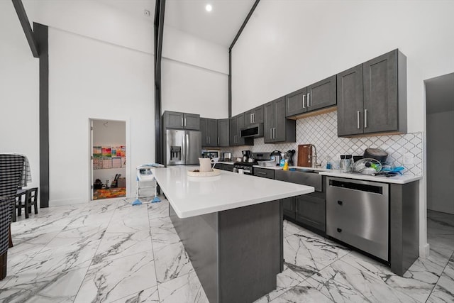 101 Old Westport Rd, Dartmouth, MA 02747 - kitchen with stainless steel appliances, light marble finish flooring, a high ceiling, light countertops, and a center island