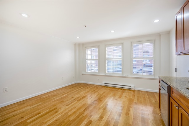 unfurnished dining area with crown molding, a baseboard heating unit, and light wood-type flooring