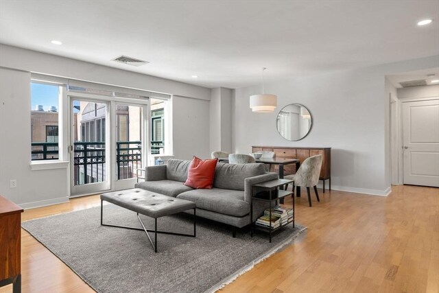 living room with light wood-type flooring, baseboards, visible vents, and recessed lighting