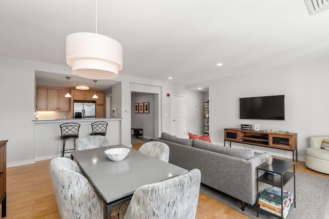 dining space featuring baseboards, light wood-type flooring, visible vents, and recessed lighting