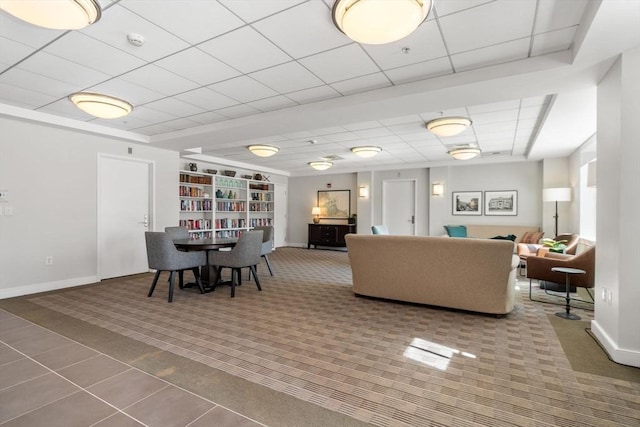 dining room with a paneled ceiling, carpet, and baseboards