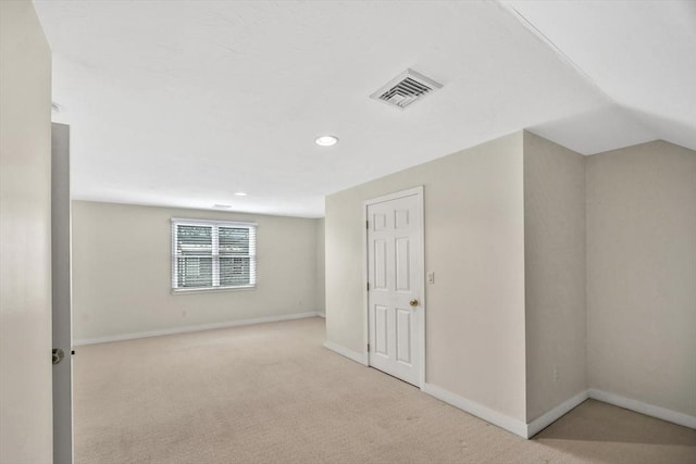 bonus room featuring light colored carpet and vaulted ceiling