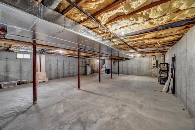 basement featuring water heater and electric panel