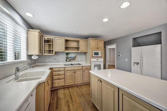 kitchen featuring white appliances, light brown cabinetry, light hardwood / wood-style flooring, and sink