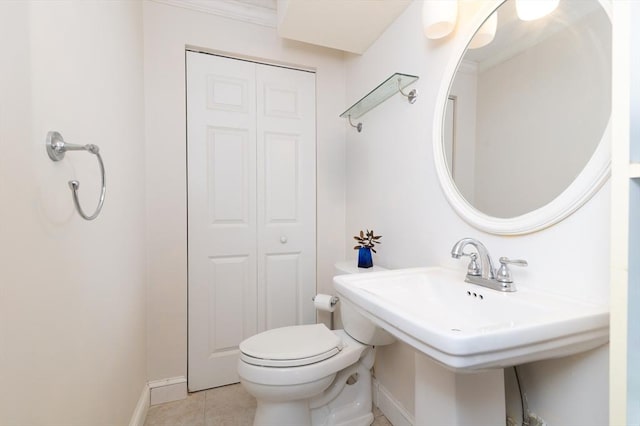 bathroom with tile patterned floors, crown molding, sink, and toilet