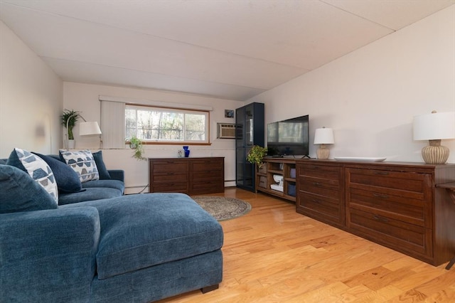 living room featuring baseboard heating, light hardwood / wood-style flooring, and a wall unit AC