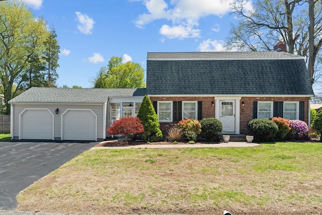 dutch colonial featuring an attached garage, a shingled roof, aphalt driveway, and a front yard