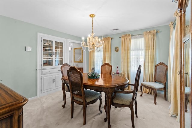 dining area with visible vents, light carpet, and a notable chandelier