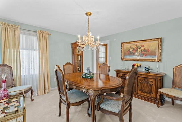 dining room with light colored carpet, baseboards, a chandelier, and a healthy amount of sunlight