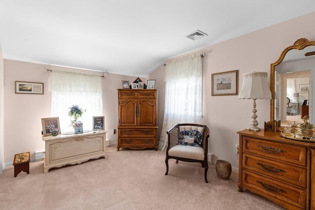 sitting room featuring light colored carpet, visible vents, and lofted ceiling