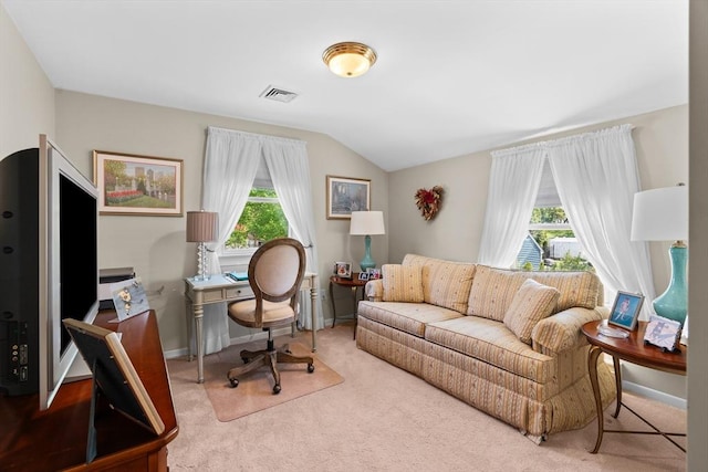 carpeted home office featuring a healthy amount of sunlight, baseboards, visible vents, and lofted ceiling