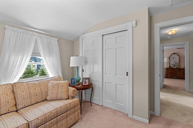 sitting room with baseboards, visible vents, light carpet, and lofted ceiling