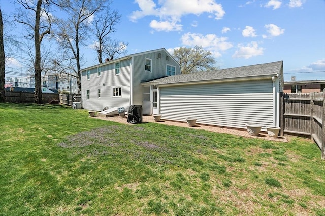 rear view of house featuring a fenced backyard and a yard