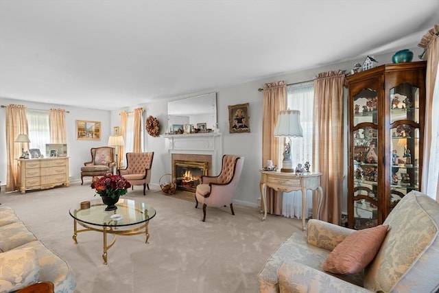 living area with a fireplace with flush hearth, carpet, and a healthy amount of sunlight