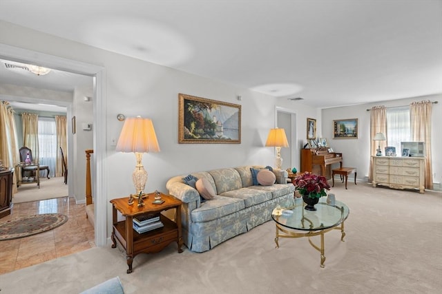 carpeted living area featuring baseboards and visible vents