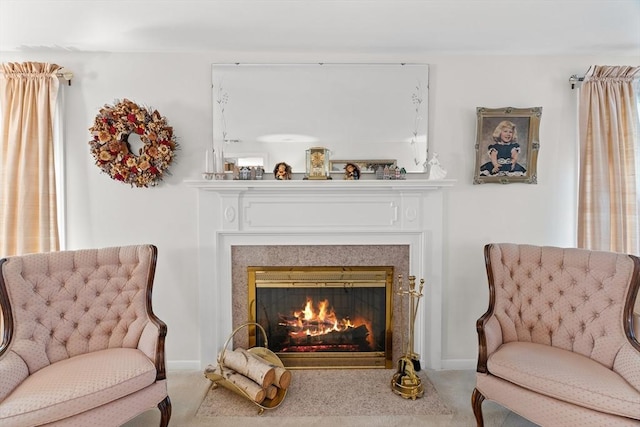 living area with baseboards, a glass covered fireplace, and carpet