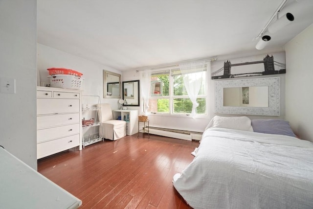 bedroom featuring dark hardwood / wood-style floors and a baseboard heating unit