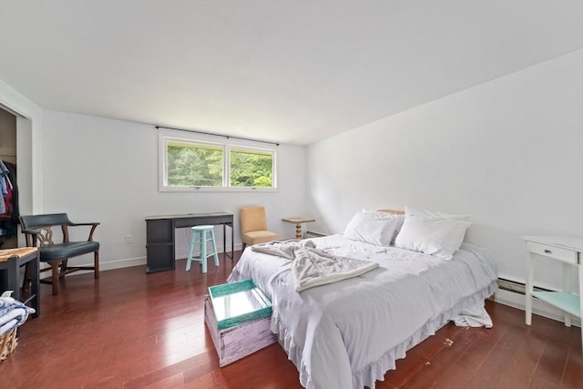 bedroom featuring a baseboard heating unit and dark wood-type flooring