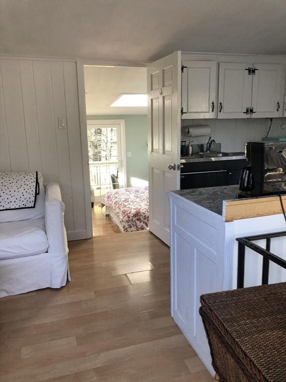 kitchen featuring white cabinetry, light hardwood / wood-style flooring, and sink