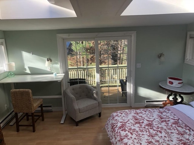 bedroom featuring hardwood / wood-style floors, access to outside, and baseboard heating