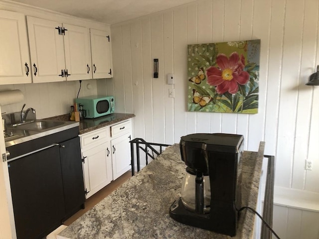 kitchen with white cabinetry, sink, and dark stone counters