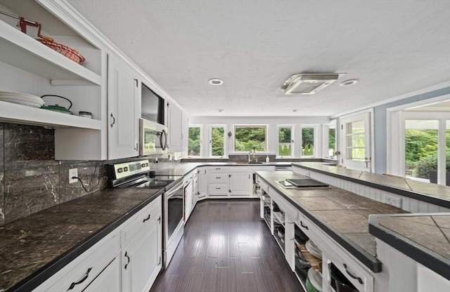 kitchen with sink, crown molding, decorative backsplash, white cabinetry, and stainless steel appliances