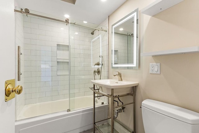 full bathroom with bath / shower combo with glass door, sink, and toilet