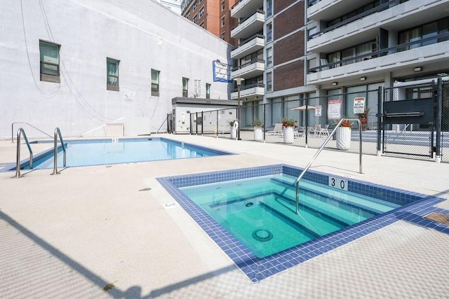 view of swimming pool featuring a community hot tub