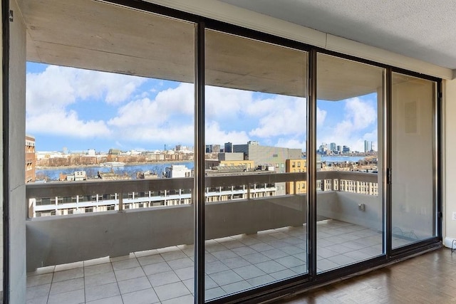 doorway to outside featuring a water view and a textured ceiling