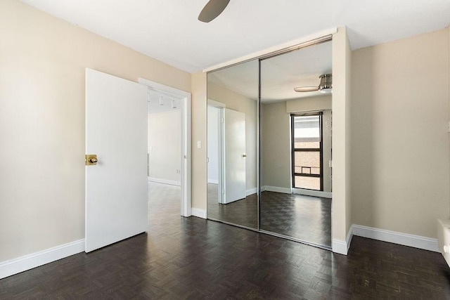 empty room featuring dark parquet flooring and ceiling fan