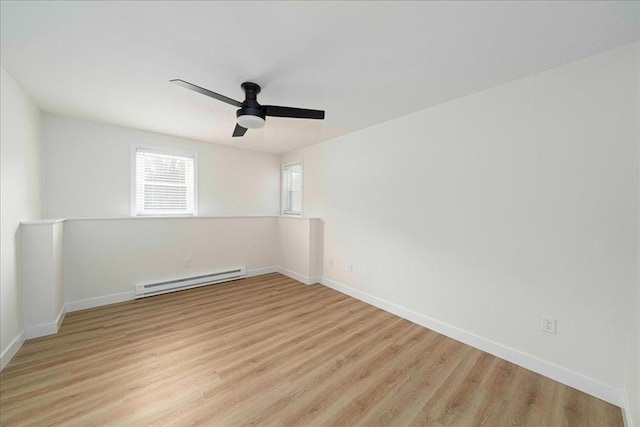 spare room featuring light wood finished floors, a baseboard radiator, baseboards, and ceiling fan