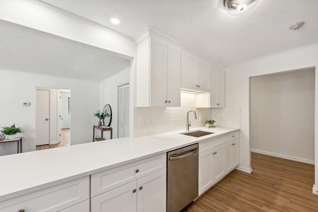 kitchen with sink, white cabinets, dishwasher, and decorative backsplash