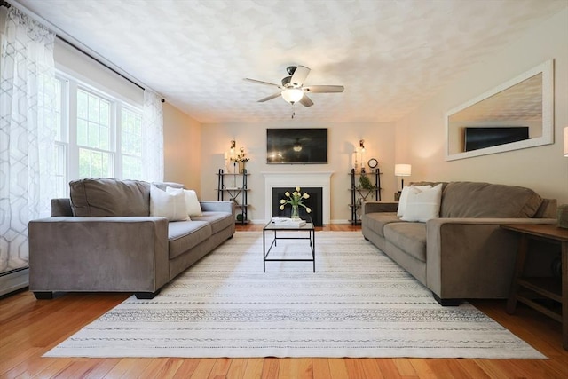 32 Lowe Meadow Ln, North Attleboro, MA 02760 - living room featuring a ceiling fan, light wood finished floors, a fireplace, and a textured ceiling