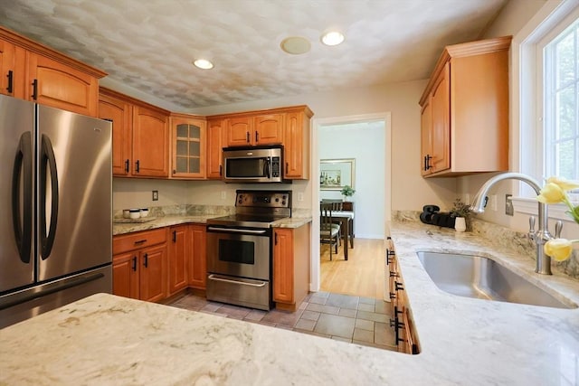 32 Lowe Meadow Ln, North Attleboro, MA 02760 - kitchen featuring stainless steel appliances, a sink, light stone counters, recessed lighting, and glass insert cabinets