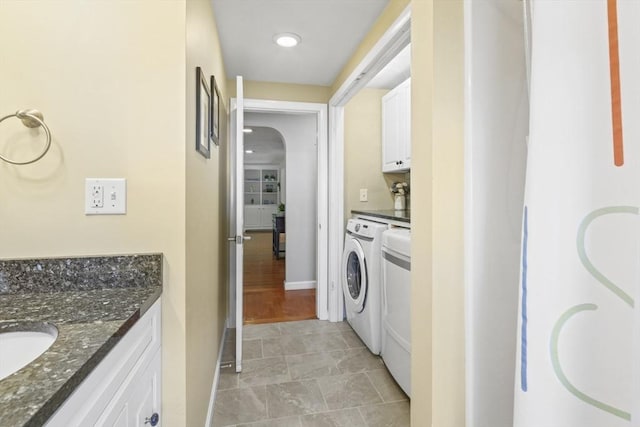 167 Montaup Ave, Dracut, MA 01826 - laundry room featuring arched walkways, cabinet space, baseboards, and washing machine and clothes dryer