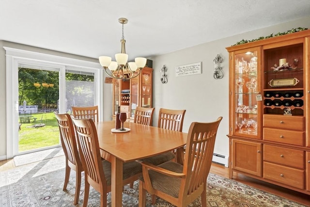 167 Montaup Ave, Dracut, MA 01826 - dining area featuring a chandelier, a baseboard radiator, and light wood-style floors