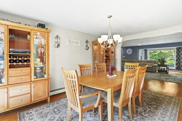 167 Montaup Ave, Dracut, MA 01826 - dining area featuring a chandelier, wood finished floors, and baseboard heating